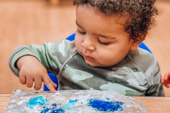Small boy playing with a winter sensory bag